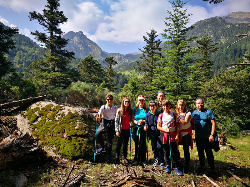 Grup de famílies amb joves adolescents envoltats dels boscos i muntanya del Parc Nacional d'Aigüestortes i Estany de Sant Maurici - Vall de Boí.