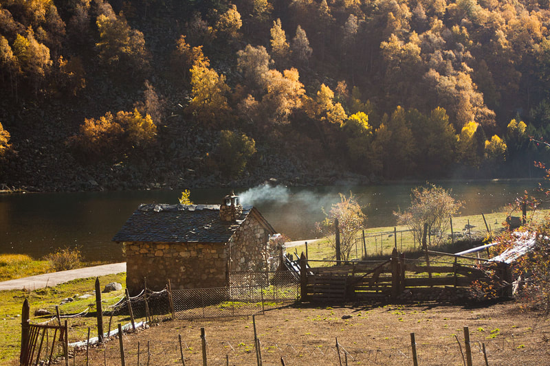 Una cabana de pastor a la vora de l'Estany Llebreta envoltada d'un bosc de tardor, al Pirineu de Lleida.